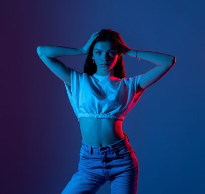 Young,Woman,Posing,Confidently,In,Blue,And,Pink,Lighting,During